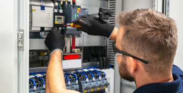 Electrician wearing safety gloves working on an electrical system