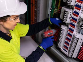 Female electrician providing maintenance services on a low voltage system